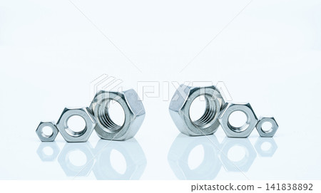 Set of metal hexagon nuts isolated on white background. Small, medium, and big of silver metal hexagon nuts. Hardware tool. Fastener with a threaded hole. Pattern of six metal nuts with copy space. 141838892