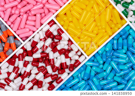 Top view of colorful capsule pills in plastic tray. Pharmaceutical industry. Healthcare and medicine. Drug production. Pharmaceutics concept. Vitamins and supplements capsules. Bright color capsule. Top view of colorful capsule pills in plastic tray. Pharmaceutical industry. Healthcare and medicine. Drug production. Pharmaceutics concept. Vitamins and supplements capsules. Bright color capsule. 141838950