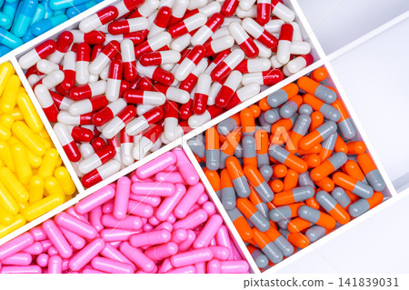 Top view of antibiotic capsule pills in plastic drug tray. Antibiotic resistance concept. Antibiotic drug selection. Drug interactions and pharmacology. Healthcare budget. Hospital drug management. Top view of antibiotic capsule pills in plastic drug tray. Antibiotic resistance concept. Antibiotic drug selection. Drug interactions and pharmacology. Healthcare budget. Hospital drug management. 141839031