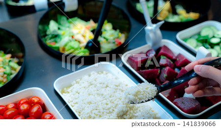 Hand holding spoon with boiled Job's tears at salad bar. Salad bar buffet at the restaurant. Fresh salad bar buffet for lunch or dinner. Healthy food. Catering food. Banquet service. Vegetarian food. Hand holding spoon with boiled Job's tears at salad bar. Salad bar buffet at the restaurant. Fresh salad bar buffet for lunch or dinner. Healthy food. Catering food. Banquet service. Vegetarian food. 141839066