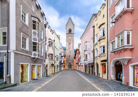 Quiet cobblestone street leading to clock tower in Italian historic town Vipiteno Sterzing Quiet cobblestone street leading to clock tower in Italian historic town Vipiteno Sterzing 141839114