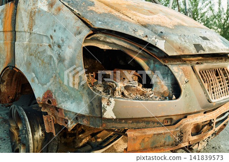 Melted Plastic Headlight and Rusty Hood of Burned Car Melted Plastic Headlight and Rusty Hood of Burned Car 141839573