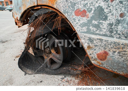Melted Exploded Car Tire and Charred Wheel Rim Detail Melted Exploded Car Tire and Charred Wheel Rim Detail 141839618
