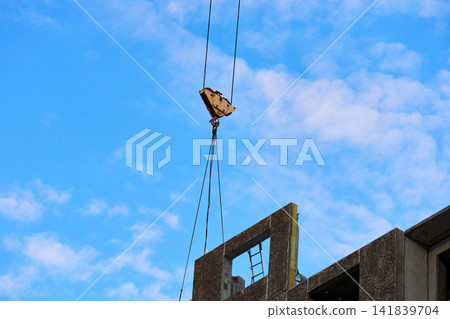 Tower crane lifting precast concrete wall panel at construction site Tower crane lifting precast concrete wall panel at construction site 141839704