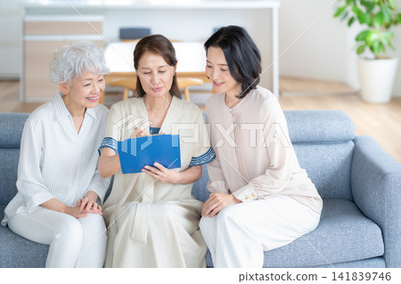 一位老年婦女正在填寫問卷，她的朋友 141839746