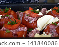 Baking dish filled with homemade stuffed tomatoes ready to be placed in the oven, showing a traditional and appetizing home cooked meal preparation. 141840086