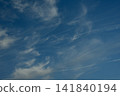 Clear blue sky with delicate cirrus clouds and visible airplane trails crossing the atmosphere, creating a peaceful natural background with subtle signs of air travel. 141840194