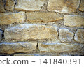 Close up view of a beige stone wall with beautiful masonry details, showing a natural architectural texture and traditional construction material. 141840391