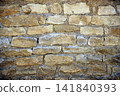 Close up view of a beige stone wall with beautiful masonry details, showing a natural architectural texture and traditional construction material. 141840393