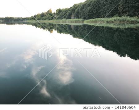 Reflection of the sky and forest in the mirror-like water of the river Reflection of the sky and forest in the mirror-like water of the river 141840604