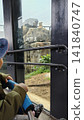 A child watching a lion at the zoo A child watching a lion at the zoo 141840747