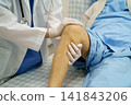 Doctor checking Asian elderly woman patient with scar knee replacement surgery in hospital. 141843206