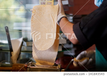 Chef Making Pasta Dough with Machine Close Up Kitchen Chef Making Pasta Dough with Machine Close Up Kitchen 141843543