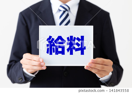 一位身穿西裝的年輕商人手持白板,上面展示著薪資單。 一位身穿西裝的年輕商人手持白板,上面展示著薪資單。 141843558