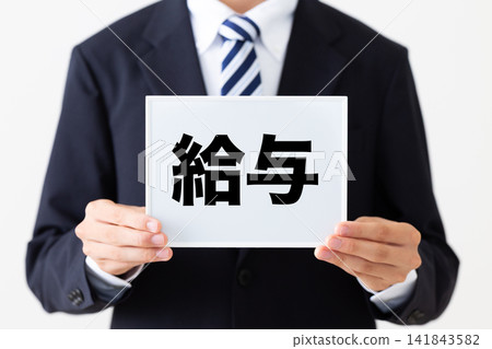 A young businessman in a business suit holding a whiteboard displaying salaries. A young businessman in a business suit holding a whiteboard displaying salaries. 141843582