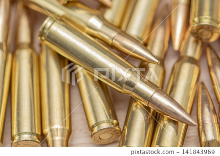 Closeup of brass rifle cartridges arranged in a scattered ammunition pile Closeup of brass rifle cartridges arranged in a scattered ammunition pile 141843969