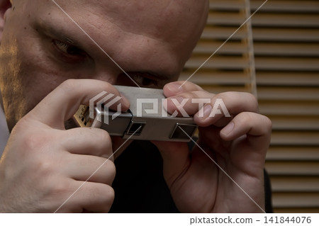 Spy photographs secret materials on a mini camera, collecting compromising material, special agent and intelligence officer , private investigator. Spy photographs secret materials on a mini camera, collecting compromising material, special agent and intelligence officer , private investigator. 141844076