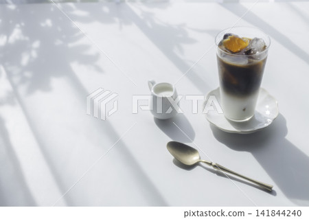 The gentle summer sunshine and iced café au lait create the image of a home café. The gentle summer sunshine and iced café au lait create the image of a home café. 141844240