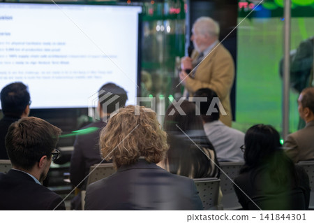 Senior speaker leads presentation for seated audience 141844301