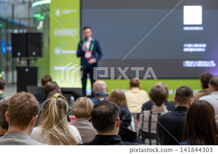Presenter speaks beside dark digital slide at conference Presenter speaks beside dark digital slide at conference 141844303