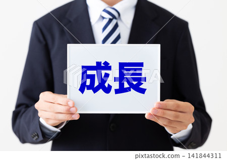 一位身著西裝的年輕商人手持白板,上面顯示著增長情況 一位身著西裝的年輕商人手持白板,上面顯示著增長情況 141844311