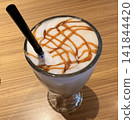 一款時尚的咖啡飲品，配有蓬鬆的奶泡和焦糖醬。 141844420