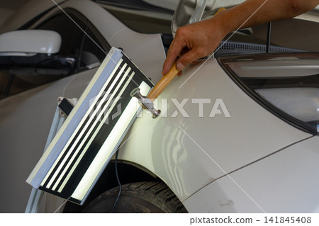 Removing dents on the car. PDR technology. Car body repair without painting. Removing dents on the car. PDR technology. Car body repair without painting. 141845408