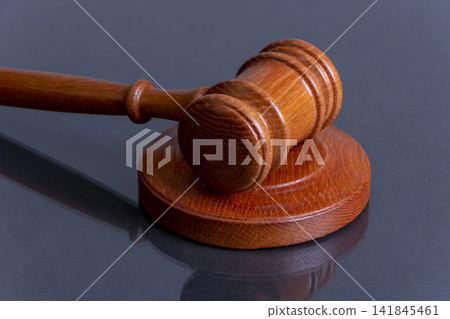A judge's gavel on a dark background, a symbol of justice and the punishment system. A judge's gavel on a dark background, a symbol of justice and the punishment system. 141845461