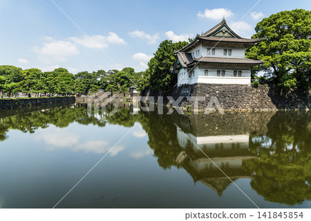 The moat's calm surface reflected the old Sakurada Tatsumi Yagura and stone walls, one of the Three Surviving Watchtowers of Edo Castle, in Tokyo Imperial Palace, Chiyoda, Japan. The moat's calm surface reflected the old Sakurada Tatsumi Yagura and stone walls, one of the Three Surviving Watchtowers of Edo Castle, in Tokyo Imperial Palace, Chiyoda, Japan. 141845854
