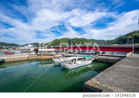 A view of the port town with ships anchored in Kada Port and a clear blue sky. A view of the port town with ships anchored in Kada Port and a clear blue sky. 141846516