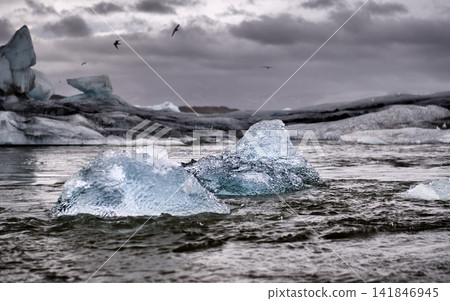 Icebergs in Glacial Lagoon Under Stormy Arctic Sky Icebergs in Glacial Lagoon Under Stormy Arctic Sky 141846945