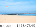 Windsock indicator of wind on the beach with yellow sand, blue sky, beautiful sea. Nature background in Ostende, Belgien. 141847345