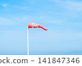 Windsock indicator of wind on the beach with yellow sand, blue sky, beautiful sea. Nature background in Ostende, Belgien. 141847346