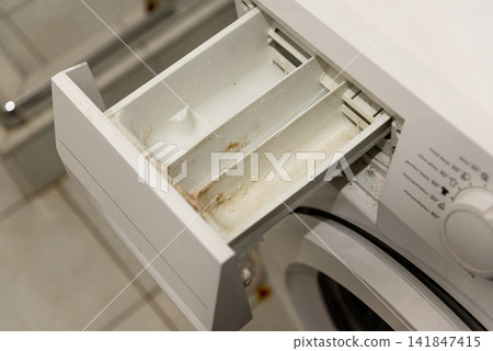 Dirty tray washing machine drawer covered detergent and limescale of solid water Dirty tray washing machine drawer covered detergent and limescale of solid water 141847415