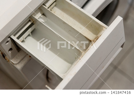 Dirty tray washing machine drawer covered detergent and limescale of solid water Dirty tray washing machine drawer covered detergent and limescale of solid water 141847416