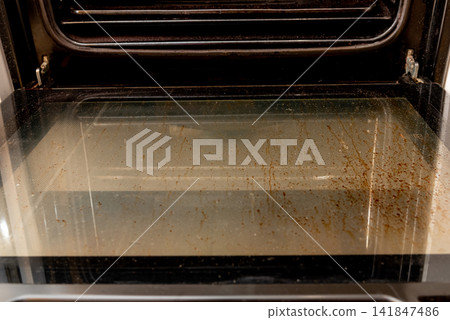 Oven with open dirty door smeared old dried grease, kitchen appliances equipment Oven with open dirty door smeared old dried grease, kitchen appliances equipment 141847486