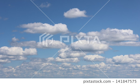 Fluffy white cumulus clouds float against a bright blue sky. Fluffy white cumulus clouds float against a bright blue sky. 141847575