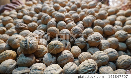 Pile of walnuts showcases natural texture with soft lighting, dry fruits concept Pile of walnuts showcases natural texture with soft lighting, dry fruits concept 141847707