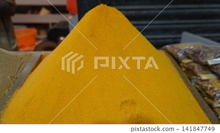 Large pile of yellow turmeric powder displayed at a traditional spice market shop, food flavorings and sales concept Large pile of yellow turmeric powder displayed at a traditional spice market shop, food flavorings and sales concept 141847749