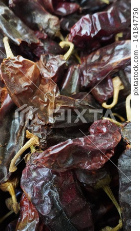 Dried whole red chili peppers piled at a traditional spice shop in a local market, organic cooking ingredient concept Dried whole red chili peppers piled at a traditional spice shop in a local market, organic cooking ingredient concept 141847750