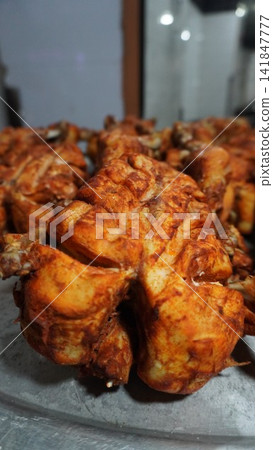 Close up of roasted chicken piece served at a local food restaurant, barbecue cooking meal and catering service concept Close up of roasted chicken piece served at a local food restaurant, barbecue cooking meal and catering service concept 141847777