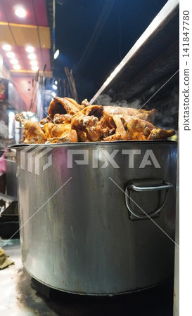 Large steel pot with cooked food on a stove at a street food stall, traditional cooking method and kitchen concept Large steel pot with cooked food on a stove at a street food stall, traditional cooking method and kitchen concept 141847780