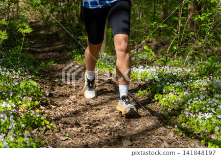 Close-up of a runners legs in white sneakers 141848197