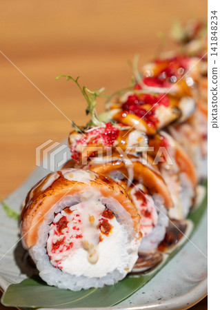 Gourmet salmon sushi rolls with cream cheese, red fish roe, and creamy sauce Gourmet salmon sushi rolls with cream cheese, red fish roe, and creamy sauce 141848234