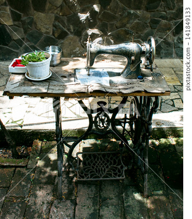 Kharkiv, Ukraine - July 15, 2021: Vintage Singer treadle sewing machine with cast iron base Kharkiv, Ukraine - July 15, 2021: Vintage Singer treadle sewing machine with cast iron base 141849133