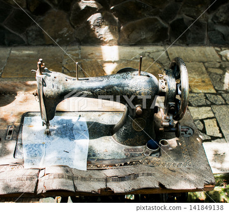 Kharkiv, Ukraine - July 15, 2021: Old Singer treadle sewing machine outdoors Kharkiv, Ukraine - July 15, 2021: Old Singer treadle sewing machine outdoors 141849138