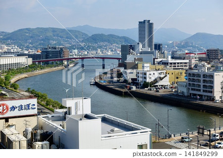 Nagasaki City's cityscape and urban landscape featuring a river and red bridge. Nagasaki City's cityscape and urban landscape featuring a river and red bridge. 141849299