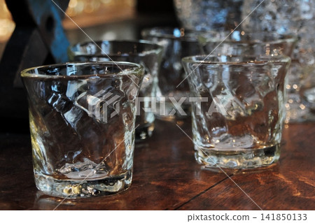 吧台上擺放著透明玻璃杯,在間接照明的映襯下閃閃發光 | 時尚的用餐氛圍 吧台上擺放著透明玻璃杯,在間接照明的映襯下閃閃發光 | 時尚的用餐氛圍 141850133