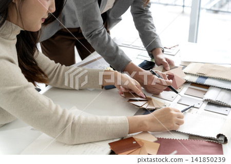 Asian adult women designers collaborate selecting material swatches color palettes for interior project planning bright modern office studio workspace Asian adult women designers collaborate selecting material swatches color palettes for interior project planning bright modern office studio workspace 141850239
