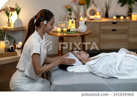 Asian adult women receive professional spa facial treatment for relaxation beauty wellness soothing skin therapy tranquil environment Asian adult women receive professional spa facial treatment for relaxation beauty wellness soothing skin therapy tranquil environment 141850468